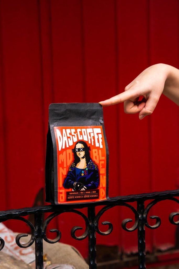 a person pointing to a pack of coffee