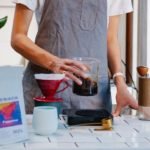 woman in apron preparing coffee in cafe